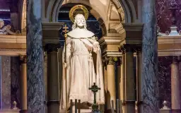 Kamienna postać króla z berłem i jabłkiem, ozdobiona złotym nimbem, stoi w monumentalnym wnętrzu bazyliki św. Stefana w Budapeszcie.