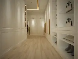 Elegancka zabudowa wąskiego przedpokoju z białymi frontami i złotymi uchwytami. Wnęki z torebkami i butami.