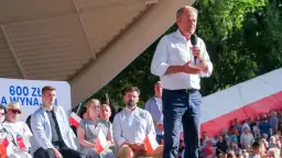 Donald Tusk przemawia w Koszalinie do zgromadzonego tłumu. Na banerze widnieje napis "600 zł".