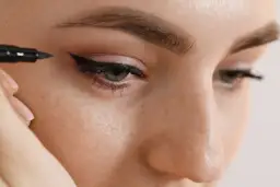 Precyzyjne kreski eyelinerem dla początkujących. Delikatna ręka maluje idealną jaskółkę.