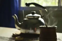 Gorąca yerba mate w drewnianym naczyniu, obok czajnik. Idealny napój, by zastanowić się, ile yerby dziennie wypić.