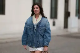 Mujer con chaqueta vaquera forrada y falda estampada. Un look casual y chic, ideal para saber con que combinar chaqueta vaquera mujer.