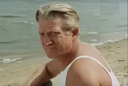 Józef Nowak, aktor, odpoczywa nad wodą w białej podkoszulce.