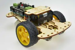 Zbuduj własnego robota z kartonu! Ten model ma drewnianą ramę, koła, baterie i płytkę sterującą.