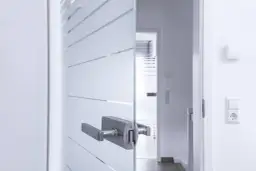 Nowoczesne szklane drzwi do łazienki z matowym wykończeniem i elegancką klamką.