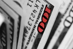Zbliżenie na banknot 100 dolarów z czerwonym oznaczeniem liczby 100.