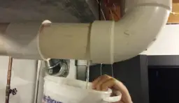 Krople wody z pieca dwufunkcyjnego lądują w wiadrze.