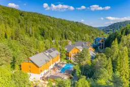Idealne miejsce, gdzie na majówkę w Polsce: hotel w otoczeniu zielonych lasów, z basenem i miejscami do wypoczynku.