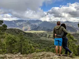 Para zakochanych podziwia malowniczy krajobraz podczas trekkingu na Gran Canarii. Góry, lasy i chmury tworzą spektakularny widok.