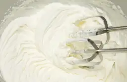 Krem na bazie śmietanki i mascarpone, puszysty i gładki, właśnie ubijany mikserem. Idealny do tortów i deserów.