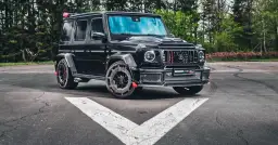 Czarny Brabus Rocket 900, czyli ile kosztuje Mercedes G klasa Brabus? Potężny SUV na tle lasu.