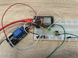 Układ do nauki, jak podłączyć przekaźnik: moduł ESP32, płytka stykowa, przekaźnik 1-kanałowy, przycisk i dioda LED.