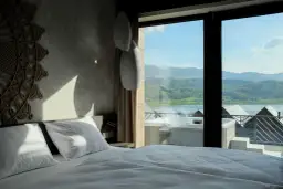 Pokój w hotelu Lake Hill z widokiem na jezioro i góry. Wanna z hydromasażem na tarasie.