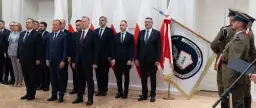 Uroczystość z udziałem premiera Tuska we Włocławku. W tle flagi Polski i ABW.