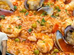 Arroz con marisco, un plato vibrante con gambas, mejillones y guisantes, listo para ser disfrutado.