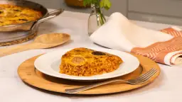 Un delicioso trozo de arroz con costra, con su capa dorada y crujiente, servido en un plato blanco.