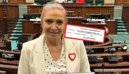 Małgorzata Niemczyk, była siatkarka, w sejmowej ławie. Na czerwonym tle dokument z jej danymi.