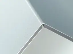 Szara, matowa powierzchnia z połyskującą krawędzią, przypominająca nowoczesny panel alucobond.