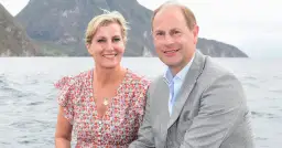 Książę Edward i hrabina Zofia uśmiechają się na tle gór i morza.