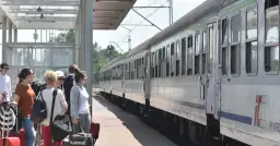 Ludzie z bagażami czekają na pociąg PKP. Zastanawiasz się, kto ma zniżki na PKP? Sprawdź ofertę przewoźnika!