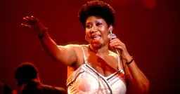 Aretha Franklin śpiewa na scenie, trzymając mikrofon. Jej dzieci z pewnością byłyby dumne z jej występu.