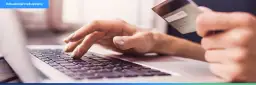 Dłonie wpisujące dane karty płatniczej na klawiaturze laptopa, ilustrujące najpopularniejsze metody płatności online.