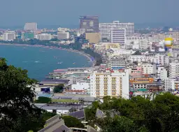 Widok na nadmorskie miasto z wieloma budynkami, plażą i morzem. Zastanawiasz się, ile kosztują mieszkania w Tajlandii?