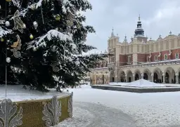 Świąteczna choinka i ośnieżone Sukiennice na Rynku Głównym. Kraków atrakcje zimą zachwycają.