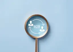Lupa powiększa schemat B2B z dwoma ludzikami w garniturach i strzałkami, symbolizującymi współpracę biznesową.