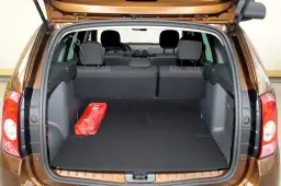 Otwarty bagażnik Dacia Duster, pokazujący jego pojemność. Czerwona apteczka leży na czarnym dywaniku.