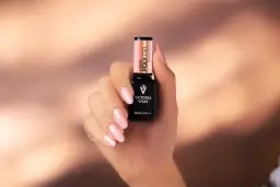 Dłoń z różowymi paznokciami trzyma buteleczkę Liquid Poly Gel Victoria Vynn. To produkt do stylizacji paznokci.