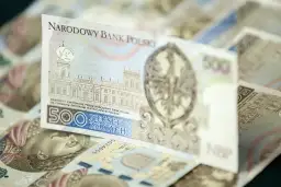 Stos banknotów 500 zł. Widoczny fragment z budynkiem i orłem.