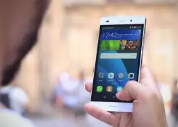 Dłoń trzyma smartfon Huawei P8 Lite, pokazując ekran z ikonami. Dowiedz się, jak zaktualizować Androida w Huawei P8 Lite.
