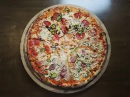 Pyszna pizza włoska z salami, pieczarkami, korniszonami i kukurydzą. Idealna na wieczór, choć warto pamiętać o jej kcal.