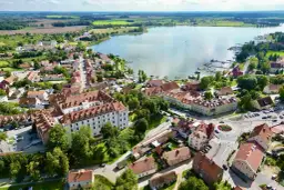 Widok z lotu ptaka na miasteczko nad jeziorem z zamkiem i mariną.