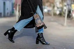 Estilo urbano: cómo combinar botines negros brillantes con jeans desgastados y un bolso bordado.