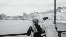Para spaceruje nad Sekwaną, podziwiając Luwr. Mówią sobie "bonsoir", czyli dobry wieczór po francusku.