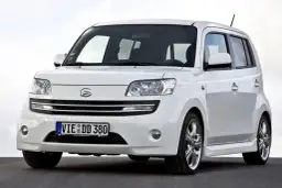 Biały Daihatsu Materia z niemieckimi tablicami rejestracyjnymi stoi na ciemnej nawierzchni.
