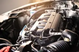 Zbliżenie na silnik samochodowy BMW E91, widoczne przewody i elementy mechaniczne.
