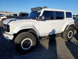 Biały Ford Bronco z USA, z dodatkowym oświetleniem na dachu i terenowymi oponami.