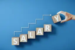 Drewniane klocki z literami tworzą napis SALARY, symbolizując drogę do jawności wynagrodzeń. Krok po kroku, ku lepszemu.