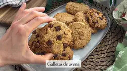 Mano tomando una galleta de avena con trozos de chocolate. Deliciosas galletas de avena caseras.