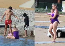 Katy Perry z dziećmi na plaży. Wokalistka w fioletowym stroju kąpielowym trzyma na rękach córkę.