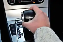 Dłoń trzymająca dźwignię zmiany biegów skrzyni DSG. Widoczne przyciski ESP OFF, AUTO HOLD i P.