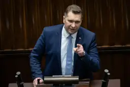 Mężczyzna w garniturze przemawia, wskazując palcem. Dyskusja dotyczy ustawy Lex Czarnek.