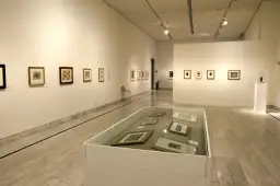 Wystawa w muzeum Picassa w Barcelonie. Obrazy na ścianach i w gablotach, marmurowa posadzka.