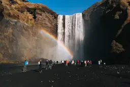 Turyści pod wodospadem Skógafoss na Islandii. Czy do Islandii trzeba mieć paszport? Tak, dla obywateli spoza strefy Schengen.