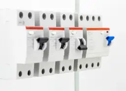 Szukasz informacji, jaki bezpiecznik do 5kW? Na zdjęciu widać rzędy wyłączników nadprądowych, które chronią instalację elektryczną.