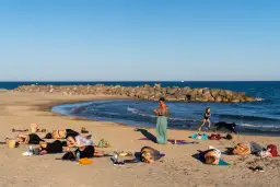 Cours de yoga sur la plage de Frontignan avec vue sur la mer et les étangs.