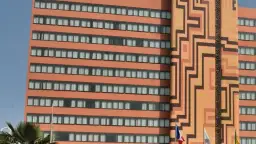 Façade d'un hôtel orange avec des motifs géométriques et des fenêtres.